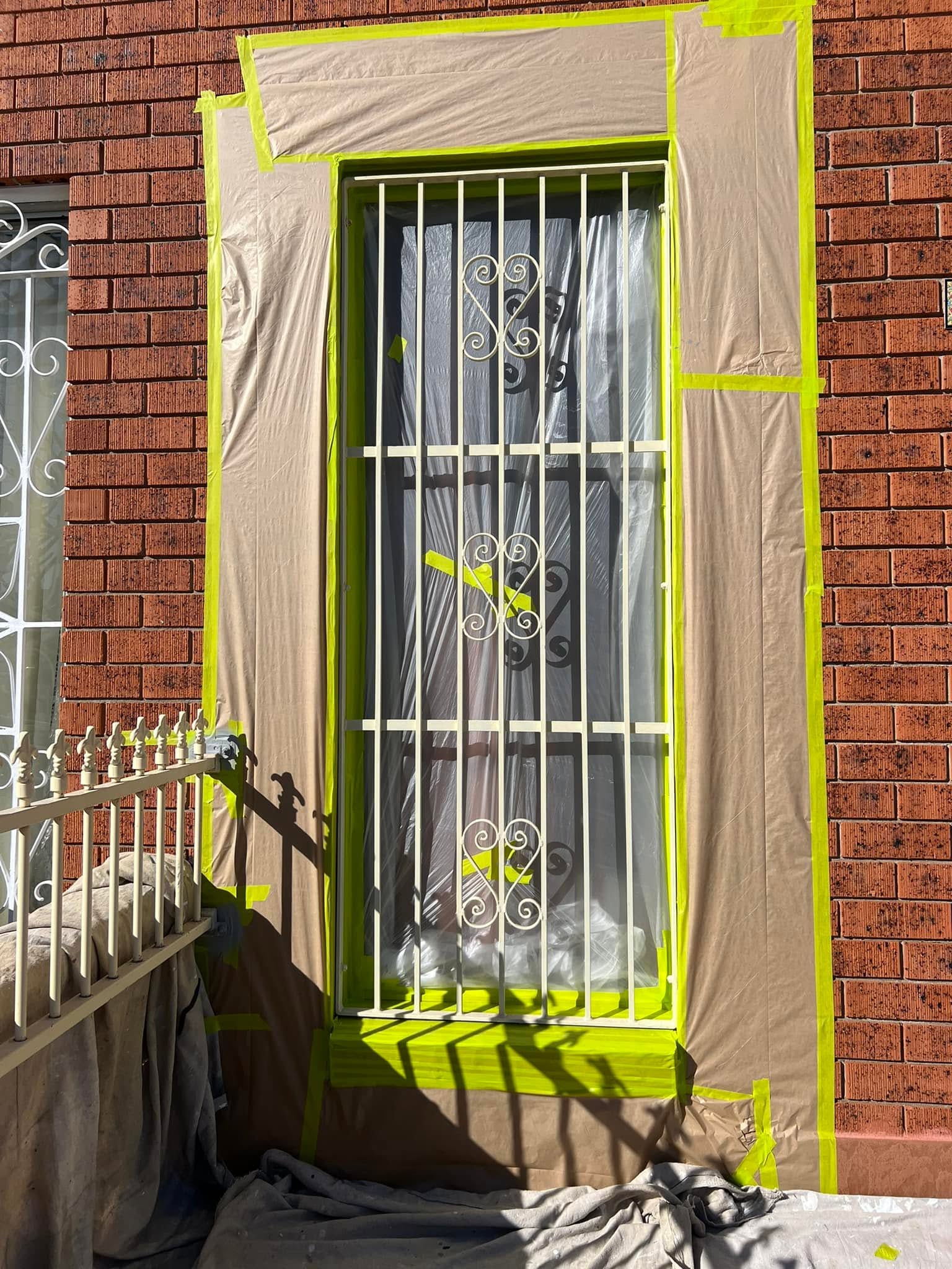 Careful masking and surface preparation on a window frame ahead of painting
